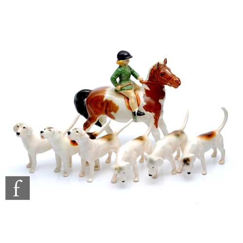 27 - A Beswick Girl on Pony, model 1499 on a skewbald horse, unmarked, together with six Beswick Foxhound... 