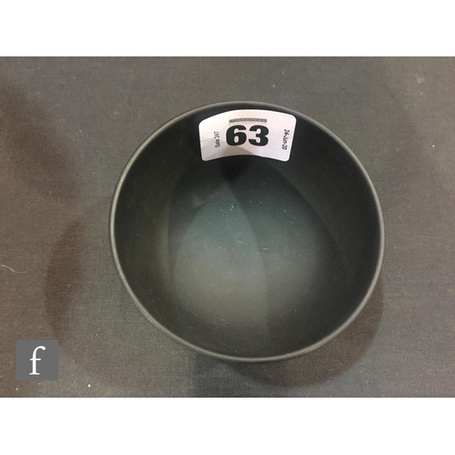 9069 - A small Wedgwood black basalt bowl of footed circular form, in the manner of Keith Murray, impressed... 