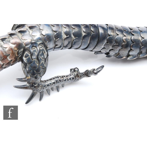1180 - An early 20th Century white metal study of an articulated Japanese dragon with two claws to each foo... 