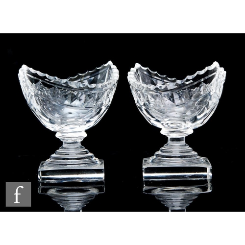 14 - A pair of late Georgian table salts of boat shape with a fluted rim, flat cut body and shallow terra... 