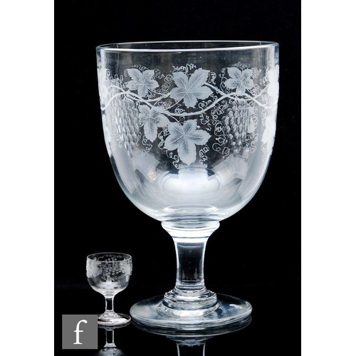 500 - A glass punch bowl formed as an oversized rummer, circa 1860, the round funnel bowl engraved and pol... 