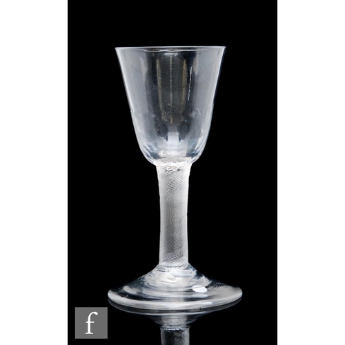 131 - An 18th Century wine glass, circa 1760, the round funnel bowl with basal moulding, above an incised ... 