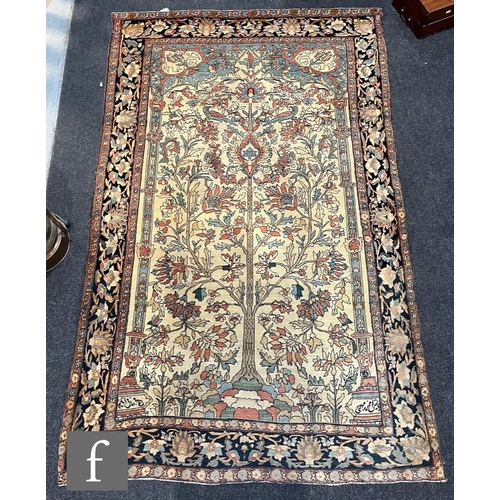 1281 - An early 20th Century Persian 'Tree of Life' pattern rug, on an oatmeal ground within foliate patter... 