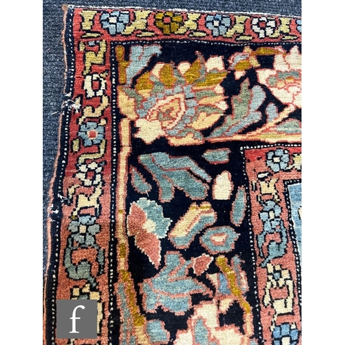 1281 - An early 20th Century Persian 'Tree of Life' pattern rug, on an oatmeal ground within foliate patter... 