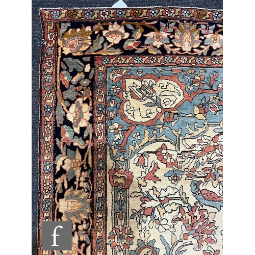 1281 - An early 20th Century Persian 'Tree of Life' pattern rug, on an oatmeal ground within foliate patter... 