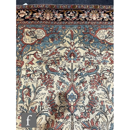 1281 - An early 20th Century Persian 'Tree of Life' pattern rug, on an oatmeal ground within foliate patter... 