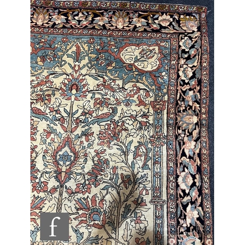 1281 - An early 20th Century Persian 'Tree of Life' pattern rug, on an oatmeal ground within foliate patter... 