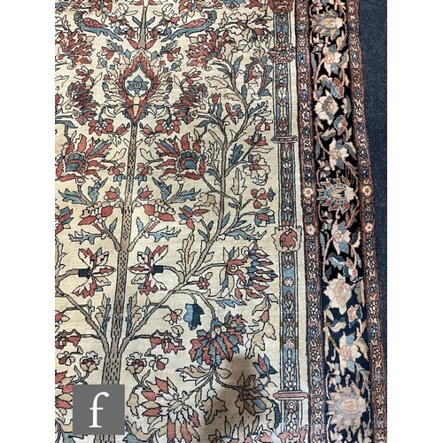 1281 - An early 20th Century Persian 'Tree of Life' pattern rug, on an oatmeal ground within foliate patter... 