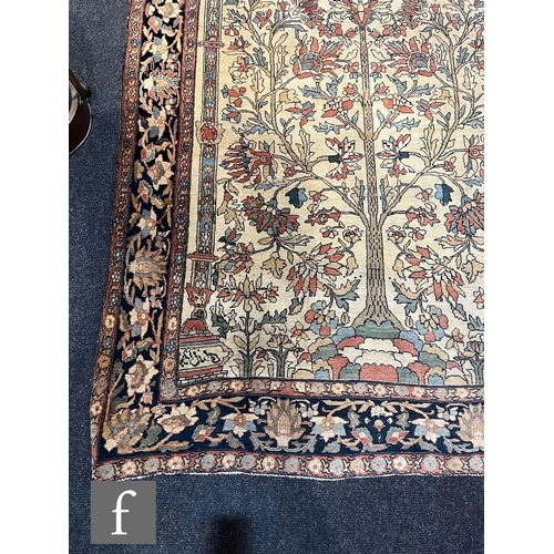 1281 - An early 20th Century Persian 'Tree of Life' pattern rug, on an oatmeal ground within foliate patter... 