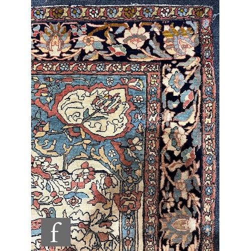 1281 - An early 20th Century Persian 'Tree of Life' pattern rug, on an oatmeal ground within foliate patter... 