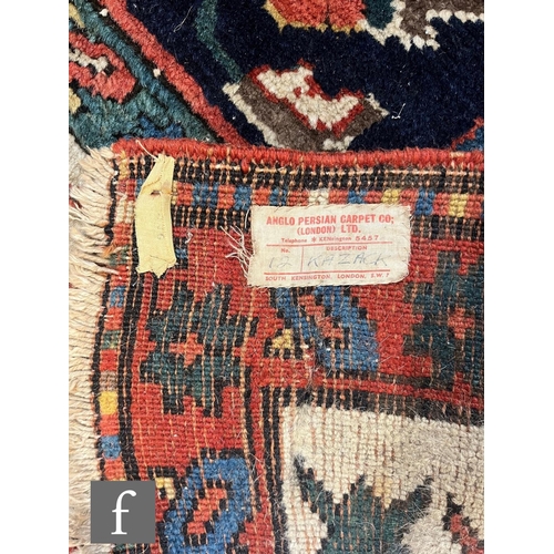 1280 - A mid 20th Century Kazak runner, the rug with repeat pattern medallions on a dark blue ground within... 