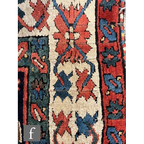 1280 - A mid 20th Century Kazak runner, the rug with repeat pattern medallions on a dark blue ground within... 