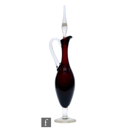 8095 - A 1950s Italian glass decanter of ewer form, the deep purple body raised to a clear foot, with appli... 