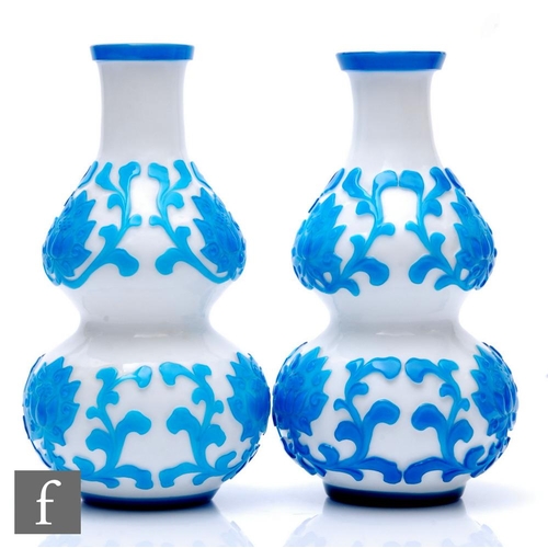 711 - A pair of early 20th Century Peking Cameo glass vases, each of double gourd form, cased in transluce... 