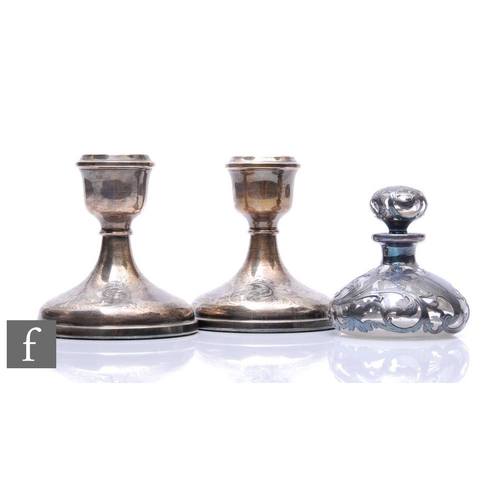 268 - A pair of hallmarked silver piano candlesticks each with engraved foliate scroll decoration to circu... 