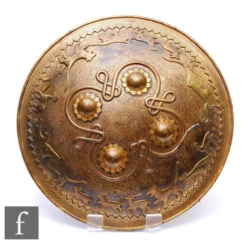 427 - A Middle Eastern brass targe shield, profusely decorated with damascended detail and four cabochons ... 