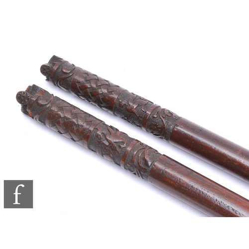 440 - A pair of 20th Century spears single and two pronged types, wooden shafts with carved decorated ends... 