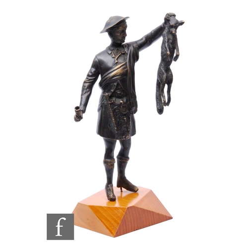 351 - A late 20th Century cast bronze figure of a Scottish huntsman holding a fox, on wooden shaped plinth... 