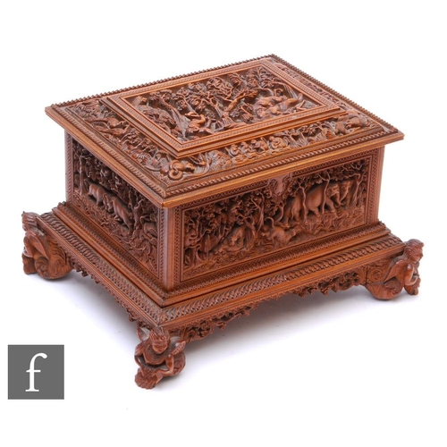 388 - A second quarter 20th Century hardwood table casket, carved in deep relief depicting elephants and t... 