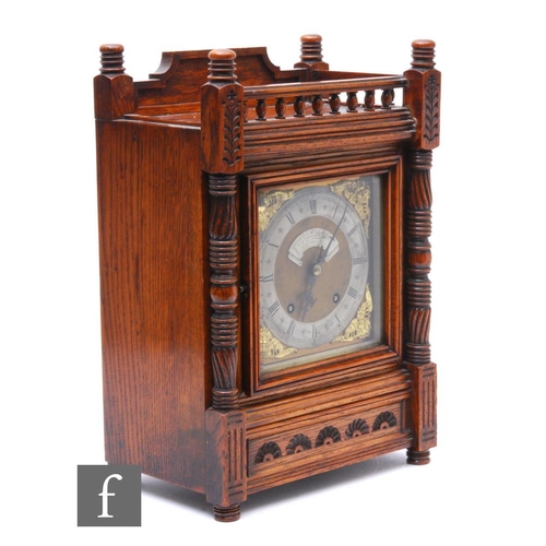 389 - A late 19th Century oak bracket clock carved in the Aesthetic taste, with spindle gallery over pilas... 