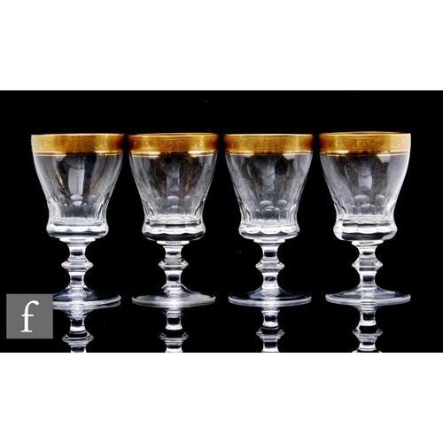 920 - Four St Louis clear crystal wine glasses, the ogee bowl with slice cut base decorated with gilt rim ... 