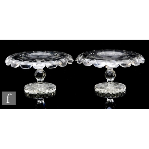 821 - A matched pair of 19th Century clear crystal pedestal tazas, each of shallow circular section with a... 