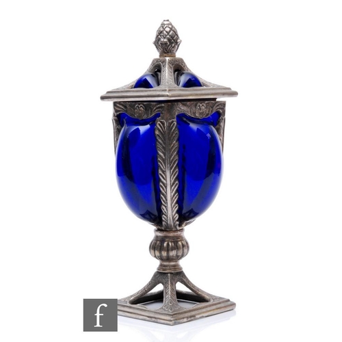 833 - A 20th Century continental metal work pedestal cup and cover with blown blue glass liner filling the... 