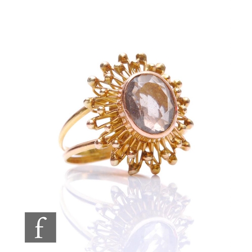 156 - An unmarked gold single stone citrine ring, oval collar set stone to a sunburst style shot border, a... 