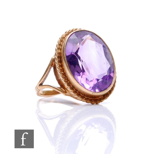 163 - A 9ct hallmarked single stone amethyst ring, oval collar set stone to a rope twist border, weight 4.... 