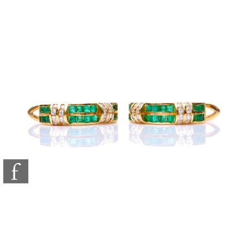 165 - A pair of 18ct emerald and diamond hinged hoop earrings, two rows of square cut emeralds spaced by d... 