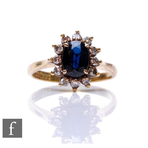 196 - An 18ct hallmarked sapphire and diamond cluster ring, central oval sapphire, length 8mm, within a bo... 