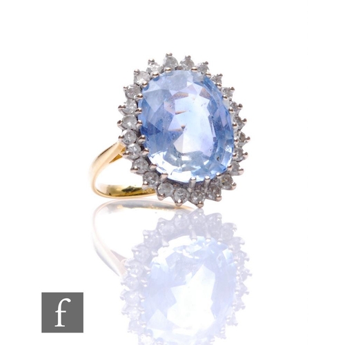 39 - An 18ct hallmarked sapphire and diamond cluster ring, central oval sapphire, length 15mm, within a b... 