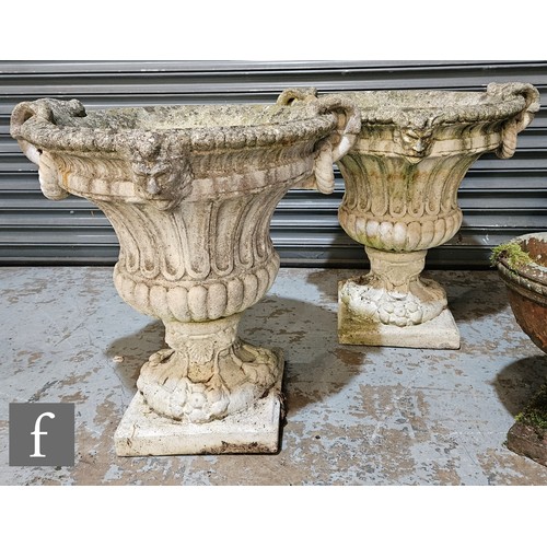 1016 - A pair of late 20th Century reconstituted stone garden terrace urns, with moulded mask mounts to the... 