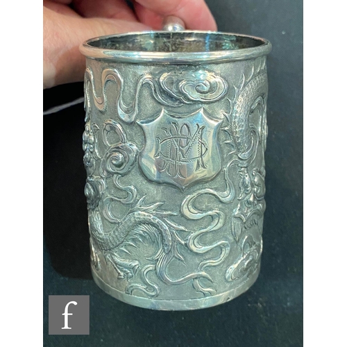 271 - An early 20th Century Chinese small silver tankard with embossed dragon decoration terminating in ba... 