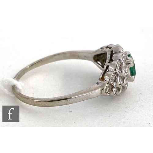 145 - An 14ct white gold emerald and diamond cluster ring, central square cut emerald to an oval diamond e... 