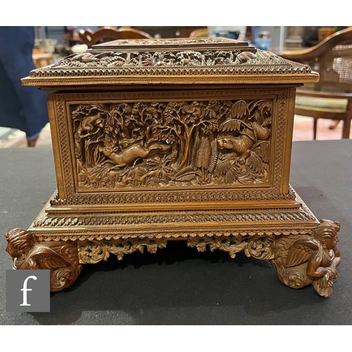 388 - A second quarter 20th Century hardwood table casket, carved in deep relief depicting elephants and t... 