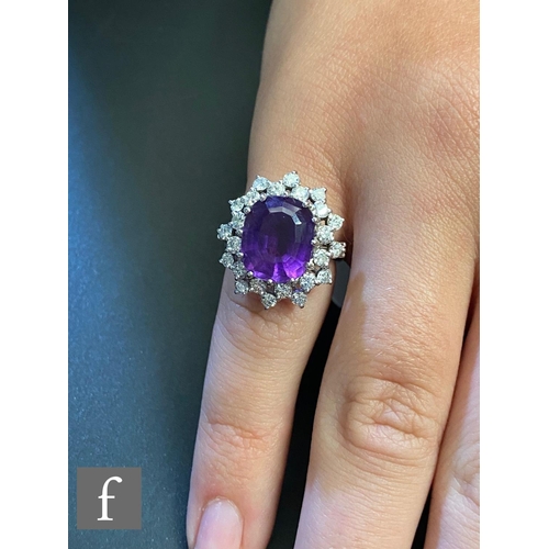 198 - An 18ct hallmarked white gold amethyst and diamond cluster ring, central oval amethyst, length 12mm,... 