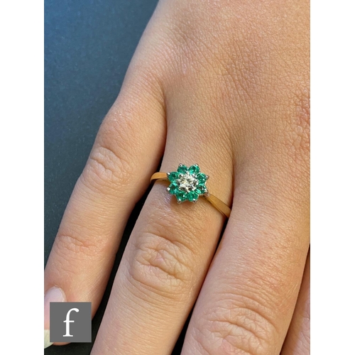 47 - An 18ct emerald and diamond cluster ring, central brilliant cut diamond within a border of eight eme... 