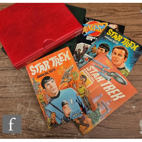 9073 - A 1975 and a 1976 Star Trek annual, a Blake 7 annual and two vinyl stamp albums.