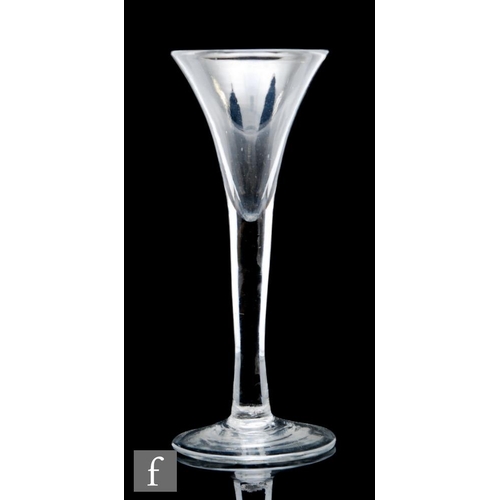 9114 - An 18th Century drinking glass circa 1740, the drawn trumpet bowl above a solid plain stem, raised t... 