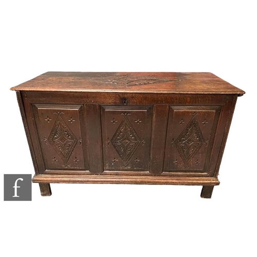 1098 - An 18th Century oak coffer chest, the triple fielded front panel with diamond carved detail, over st... 