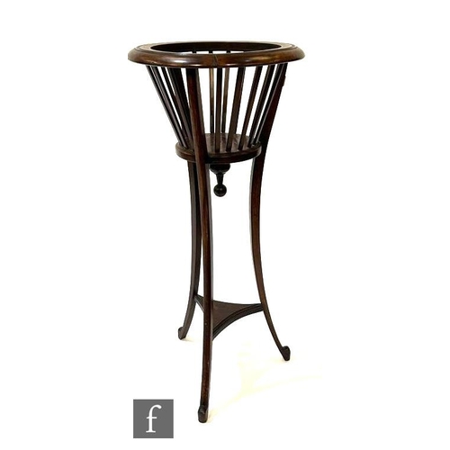 1100 - An Edwardian mahogany jardiniere stand, with slender lath sides, over splayed legs united by a trian... 