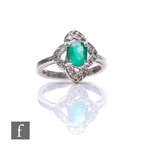 669 - A 14ct white gold emerald and diamond ring central oval emerald within a shaped diamond set border, ... 