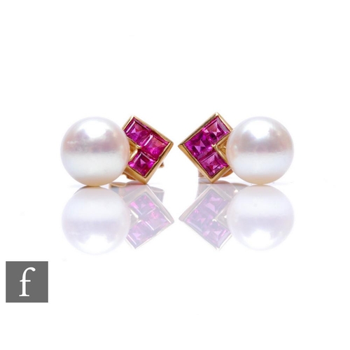 682 - A pair of 9ct cultured pearl and ruby stud earrings, three square cut rubies above a single pearl.