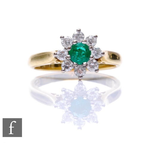 691 - An 18ct hallmarked emerald and diamond cluster ring, central circular emerald within a border of eig... 