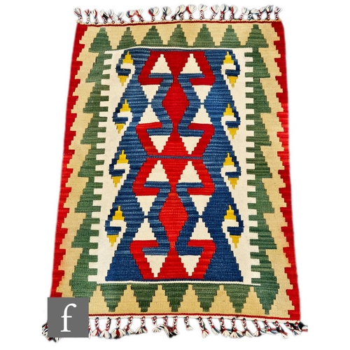 1110 - Three small flat weave Kilim rugs, the first of blue, orange and brown colours and bearing a Shiraz ... 