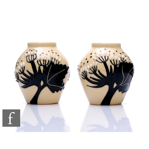 109 - Moorcroft Pottery - A pair of miniature vases, of ovoid form, decorated with stylised flowers and fo... 