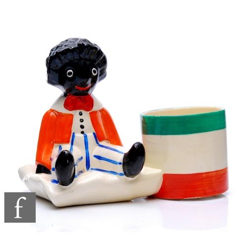 357 - Clarice Cliff - Golly - A novelty pen holder circa 1930 in the form a seated Golly wearing orange ja... 