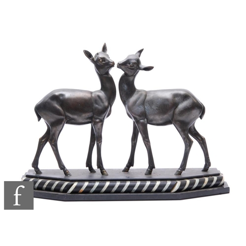 522 - After Irenee Rochard - A spelter study of two young standing deer or fawns, mounted on a black marbl... 