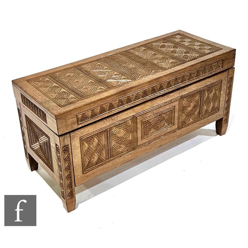 617 - An African hardwood linen or blanket chest, carved overall with geometric patterned panels and raise... 